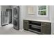 Functional laundry room with stacked washer and dryer, stainless fridge, and countertop with storage cabinets at 11974 Volcanic Rock Dr, Fishers, IN 46037