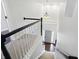 Well-lit staircase with carpeted steps and black and white railing, leading to front door at 11974 Volcanic Rock Dr, Fishers, IN 46037