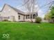 View of home's backyard with green grass, storage shed, and screened-in porch on an overcast day at 13921 Leatherwood Dr, Carmel, IN 46033