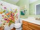 Bright bathroom features a floral shower curtain and wood-look flooring at 13921 Leatherwood Dr, Carmel, IN 46033