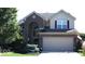 Charming two-story brick home with attached two car garage and a manicured front lawn at 13921 Leatherwood Dr, Carmel, IN 46033