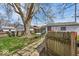 Private backyard with a large tree, stone path, grill, and a wood fence at 1441 N Euclid Ave, Indianapolis, IN 46201