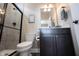 Bathroom with a glass-enclosed shower, toilet, and vanity with a dark wood cabinet at 14918 Dawnhaven Dr, Westfield, IN 46074