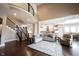 Open-concept living room with stairs, kitchen, hardwood floors, and comfortable furnishings at 14918 Dawnhaven Dr, Westfield, IN 46074