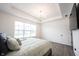 Primary bedroom with tray ceiling, ample light, and wood-look flooring at 15109 Larchwood Dr, Westfield, IN 46074