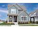 Charming two-story home with blue siding, brick accents, a covered front porch, and manicured landscaping at 15109 Larchwood Dr, Westfield, IN 46074