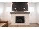 Close-up of a modern fireplace with a tiled surround, wooden mantle, and wall-mounted TV at 15109 Larchwood Dr, Westfield, IN 46074