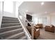 Open-concept living space with a fireplace, large windows, a staircase, and plenty of natural light at 15109 Larchwood Dr, Westfield, IN 46074