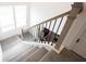 Carpeted staircase featuring sleek metal railing accents leading to the next level of the home at 15109 Larchwood Dr, Westfield, IN 46074