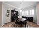 Dining room with wood floors features a round table, black hutch and sideboard with wine rack at 15591 Heatherbank Dr, Westfield, IN 46074