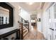 Elegant hallway featuring hardwood floors, staircase with iron spindles, and a view to the living room at 15591 Heatherbank Dr, Westfield, IN 46074