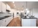Well-lit kitchen with white cabinets, dark countertops, and hardwood floors at 15591 Heatherbank Dr, Westfield, IN 46074