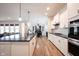 Bright, modern kitchen features white cabinetry, stainless steel appliances, and a large island with a black countertop at 15591 Heatherbank Dr, Westfield, IN 46074