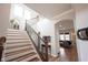 Stylish staircase showcasing hardwood steps, iron railings, and an open design leading to the upper level at 15591 Heatherbank Dr, Westfield, IN 46074
