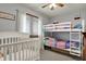 Bright bedroom features a bunk bed, crib, and natural light from the window at 1687 E 600 N, Whiteland, IN 46184