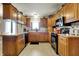 Charming kitchen features wooden cabinets, black appliances, tile floors and ample counter space at 1687 E 600 N, Whiteland, IN 46184