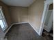 Compact bedroom featuring soft carpeting, a bright window, and an adjacent bathroom for convenience at 1830 Nichol Ave, Anderson, IN 46016