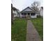 Charming single-story home with a welcoming front porch and accessible ramp in a lush, green lawn at 1830 Nichol Ave, Anderson, IN 46016