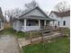 Exterior view of a light blue single-story home featuring a charming front porch and an accessible ramp at 1830 Nichol Ave, Anderson, IN 46016