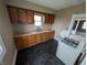 Compact kitchen featuring wooden cabinets, a double sink, and a black patterned floor at 1830 Nichol Ave, Anderson, IN 46016