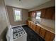Efficient kitchen layout with wooden cabinets, a stainless steel sink, and black flooring at 1830 Nichol Ave, Anderson, IN 46016