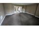 View of a living room with neutral-toned walls, carpet flooring, and an open doorway leading to another room at 1830 Nichol Ave, Anderson, IN 46016