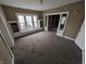A cozy living room with carpeted floors, windows with built-in seating, and an open doorway at 1830 Nichol Ave, Anderson, IN 46016