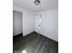 Clean and bright bedroom with new, gray, vinyl flooring and an open closet at 2111 Central Ave, Anderson, IN 46016