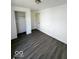 Bright bedroom featuring neutral walls, new vinyl flooring, and an open closet at 2111 Central Ave, Anderson, IN 46016