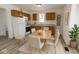 Eat-in kitchen with warm wood cabinets, white appliances, neutral countertops, and a dining table with seating at 2111 Central Ave, Anderson, IN 46016