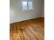 Bedroom features hardwood flooring and a window overlooking the yard at 2146 Lawrence Ave, Indianapolis, IN 46227
