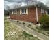 Brick house exterior with yellow shuttered windows, a path, and minimal landscaping at 2146 Lawrence Ave, Indianapolis, IN 46227