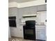 Functional kitchen with grey cabinets and black appliances for convenient meal preparation at 2146 Lawrence Ave, Indianapolis, IN 46227