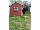Backyard shed featuring a window, white trim, and surrounded by greenery at 2146 Lawrence Ave, Indianapolis, IN 46227