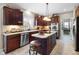 Well-lit kitchen features dark cabinetry, an island with cooktop, and stainless steel appliances at 2170 Running Brook Ln, Greenwood, IN 46143