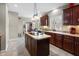 Spacious kitchen features dark wood cabinets, center island with cooktop, and bright natural lighting at 2170 Running Brook Ln, Greenwood, IN 46143
