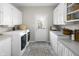 Functional laundry room with white cabinets, countertops, modern washer and dryer, and access to the yard at 2170 Running Brook Ln, Greenwood, IN 46143
