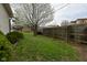 Landscaped backyard offers a green lawn, blooming tree, and privacy fence for outdoor enjoyment at 218 Demarest Dr, Indianapolis, IN 46214