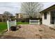 Charming backyard with a brick patio, white fencing and blooming tree, offering a serene outdoor space at 218 Demarest Dr, Indianapolis, IN 46214