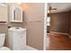 A bathroom featuring a white sink and wood flooring, with an open door to a bedroom at 218 Demarest Dr, Indianapolis, IN 46214