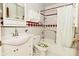 Traditional bathroom with a vanity sink, toilet, and a shower-tub combination with decorative tile accents at 218 Demarest Dr, Indianapolis, IN 46214
