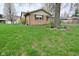Brick home with a well-maintained lawn, mature trees, and established landscaping at 218 Demarest Dr, Indianapolis, IN 46214