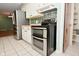 Bright kitchen featuring stainless steel double oven, refrigerator, and convenient tile flooring for cooking and dining enjoyment at 218 Demarest Dr, Indianapolis, IN 46214