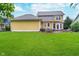 Expansive backyard featuring a well-maintained lawn, patio with a fire pit, and a two-story home at 2353 Woodcreek Crossing Blvd, Avon, IN 46123