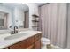 Well-lit bathroom with a vanity, decorative shelves, and a shower with beige curtain at 2353 Woodcreek Crossing Blvd, Avon, IN 46123