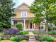 Charming two-story home featuring a covered front porch and professionally landscaped front yard at 2353 Woodcreek Crossing Blvd, Avon, IN 46123