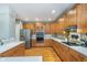 Bright kitchen featuring wood cabinets, stainless steel appliances and a brick backsplash over light countertops at 2353 Woodcreek Crossing Blvd, Avon, IN 46123