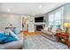 Cozy living room with a stone fireplace, neutral sofas, and a large window at 2353 Woodcreek Crossing Blvd, Avon, IN 46123