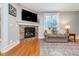 Bright living room featuring a stone fireplace, hardwood floors, and stylish decor at 2353 Woodcreek Crossing Blvd, Avon, IN 46123