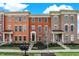 Beautiful brick townhomes feature manicured lawns, landscaping, and inviting front porches for curb appeal at 2627 Congress St, Carmel, IN 46032